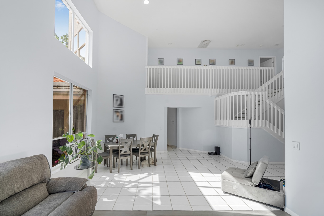 Double-story atrium with white staircase, bright Florida home interior
