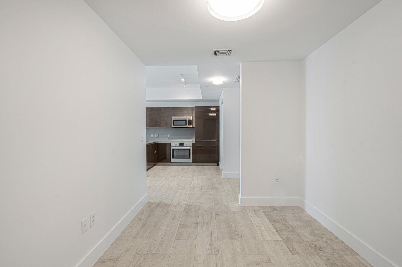 Empty Sunny Isles condo interior with light wood floors