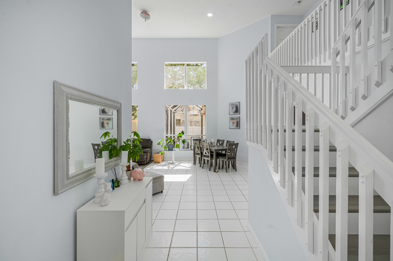 Staged entryway with mirror, white console table and staircase